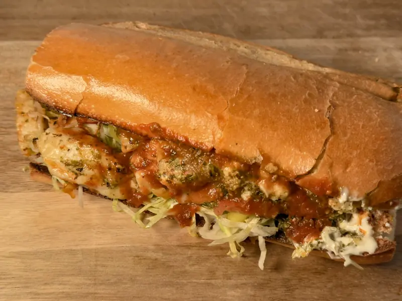 The Spicy Momma on a soft roll, layered with chicken, melted pepper jack, pesto, chipotle sauce and shredded lettuce.