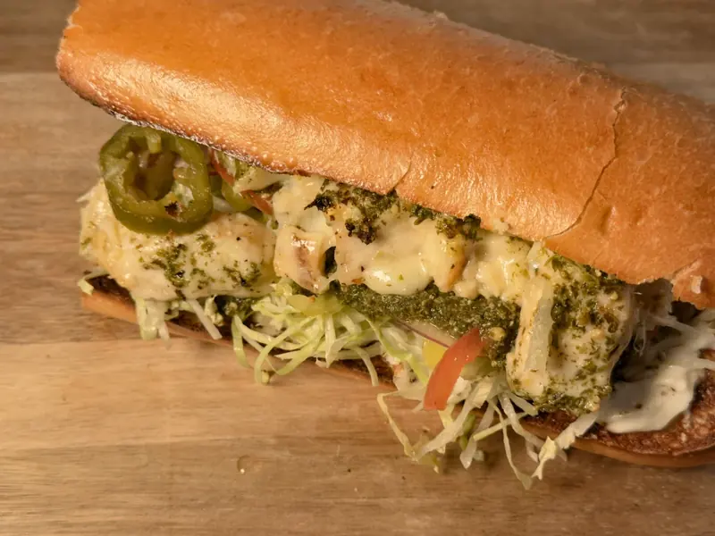 The Fillmore on a soft roll, layered with chicken, pesto, melted cheese, shredded iceberg lettuce, tomato and sliced jalapeño.